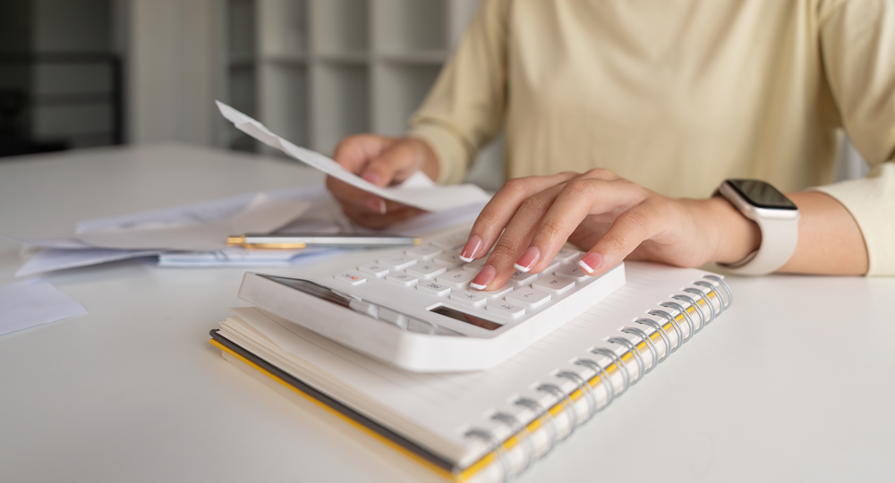 Person using calculator for financial planning.