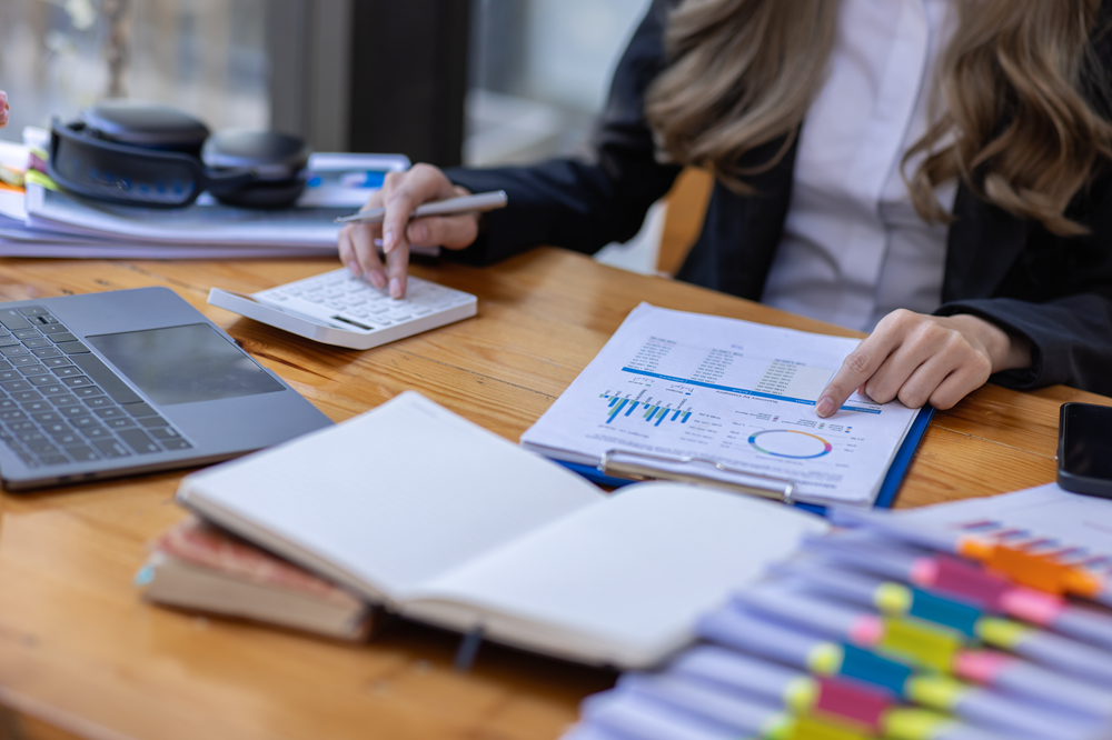 Businesswoman analyzing financial data with a calculator