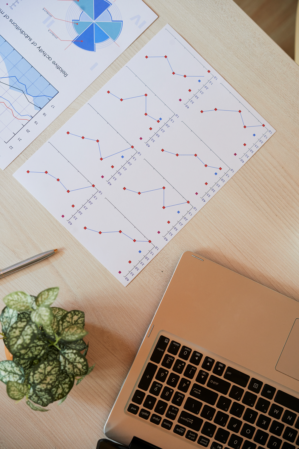 Laptop and charts on a wooden desk