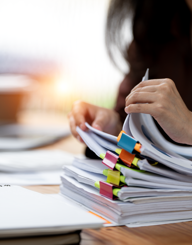 Person organizing documents with colorful tabs.