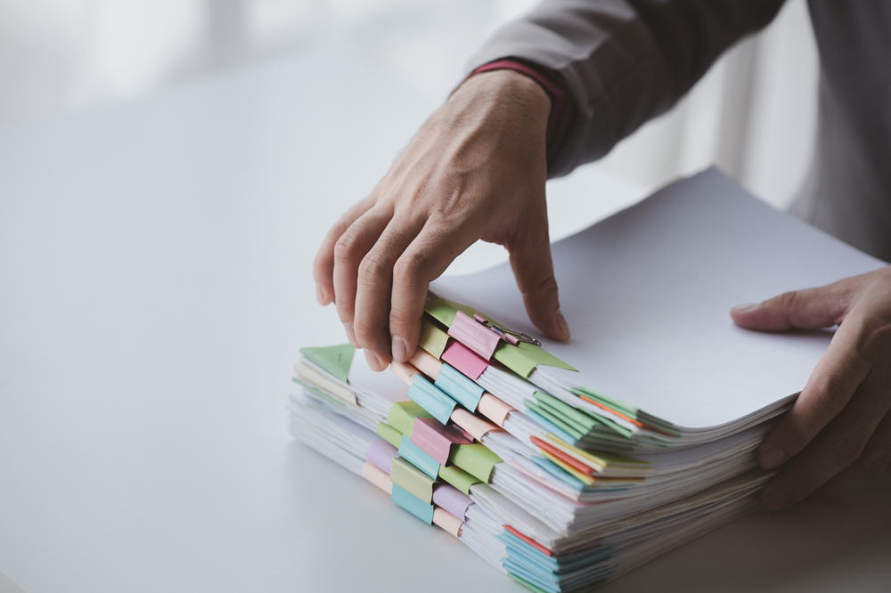 Person organizing stack of documents with clips