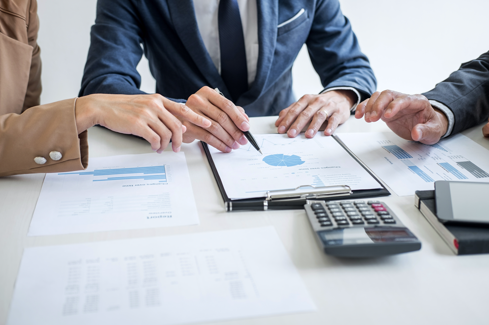 Business meeting analyzing financial documents and charts